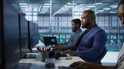 Portrait of happy server room worker developing disaster recovery plans ensuring minimal downtime. Smiling technician in data center using data analytics to monitor performance, camera A