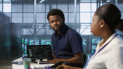 IT specialists in data center doing brainstorming, maintaining company network infrastructure. Team...