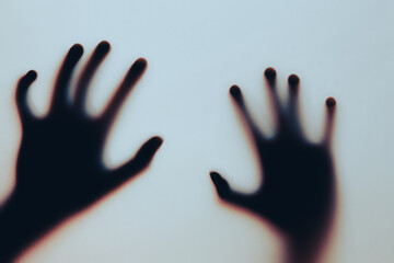 Silhouette of Hands on Blurred Glass Evoking Mystery and Suspense