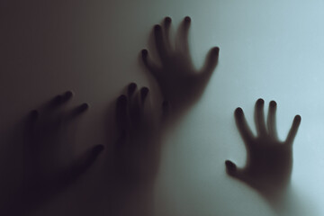 Silhouetted Hands Pressed Against a Foggy Background Creating an Eerie Atmosphere