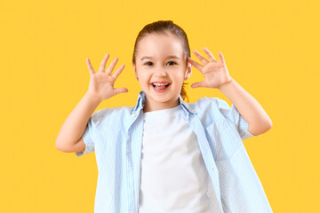 Cute little girl smiling on yellow background