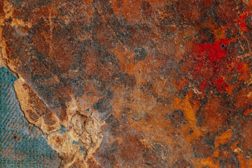 Close-up of a weathered surface book cover showcasing reddish brown, orange, blue, and black hues....