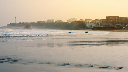 View of the beach and lighthouse of Biarritz on the Atlantic coast of southwest France. Waves, sunset, surfers