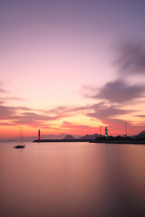 Fototapeta premium Seascape at sunshine. Lighthouse and sailings on the coast. Seaside town of Turgutreis and spectacular sunshine. Selective Focus. Long Exposure shoot. tranquility scene.