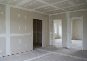 Unfinished interior room with drywall installation and natural light through windows