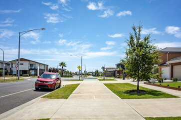 A concrete bike lane runs through a new residential development, parallel to a footpath lined with...