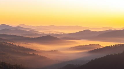 Fototapeta premium Layers of mountainous hills covered in morning mist at dawn