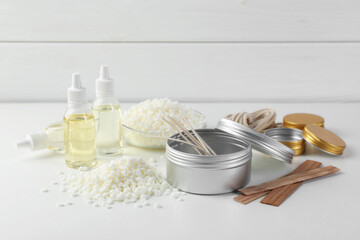 Soy wax and other supplies for making candles on white table