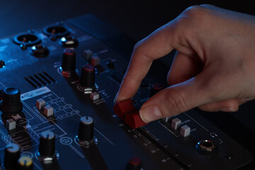 Woman working with professional mixing console at table, closeup