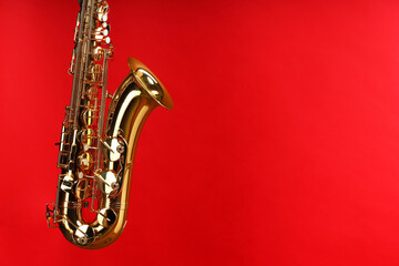 Jazz. One beautiful saxophone on red background, space for text
