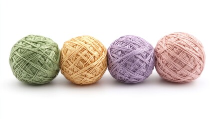 Obraz premium Four pastel yarn balls in a row on white.