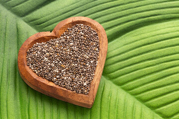 Fresh organic chia seeds in heart shaped container - Salvia hispanica.