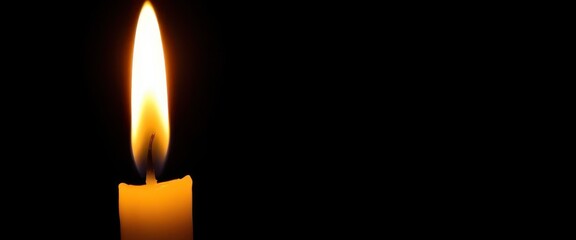 Isolated flickering candle flame, bright orange and yellow against a black background, cozy, light
