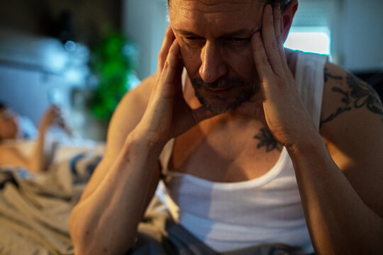 Man struggling with insomnia and stress in bedroom