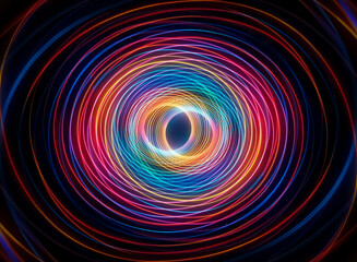 Vibrant swirl of light and color creates a mesmerizing circular abstract pattern on a dark backdrop, evoking energy and motion.