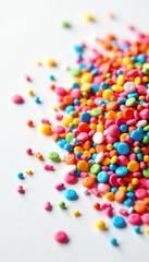 Rainbow sprinkles scattered on white, dense cluster , decoration, top view