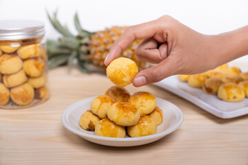 Traditional Nastar Cookies in a white plate with Hand Reaching In