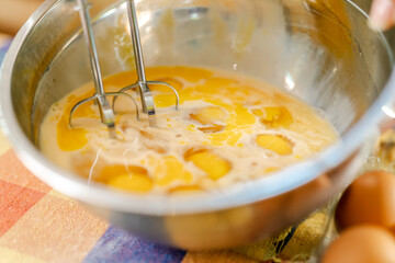 Pastry chef whisking eggs in bowl for baking recipe
