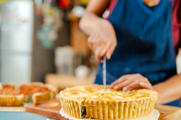 Chef cutting freshly baked chard tart in professional kitchen