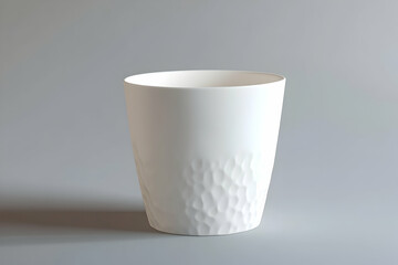 Elegant white ceramic vase with textured detail on a gray backdrop