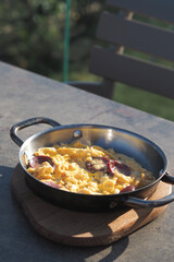 Delicious homemade scrambled eggs in a skillet on a sunny day