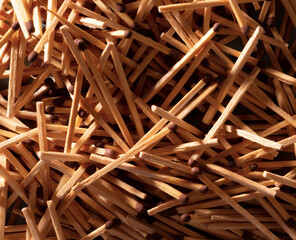 Pile of Wooden Matches with Dark Ignition Heads in Closeup View