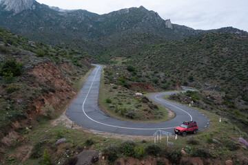 Aerial drone photo of red 4x4 American offroad SUV vehicle parked on Kapan-Shikahogh-Meghri Motorway highway pass near Armenian-Iranian border in Syunik province (Zengezur) © Hrach