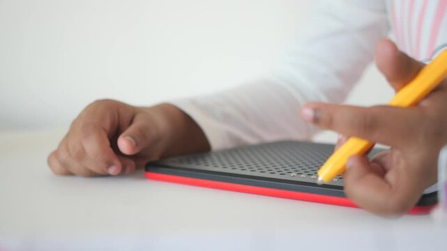 Child Engaging with Magnetic Dot Drawing Board for Creative Play
