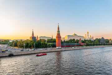 Obraz premium View of Kremlin with Vodovzvodnaya tower, Grand Kremlin Palace from repaired Bolshoy Kamenny Bridge in Moscow city on sunny summer day. Cruise ship sails on the Moscow river