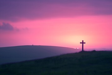 Soft pastel pink sky at sunrise with a silhouetted cross on a rolling hilltop
