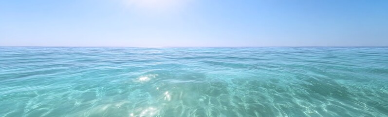 Fototapeta premium Vast, tranquil ocean under a bright blue sky, reflecting sunlight on clear water.