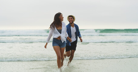 Couple, beach and holding hands on vacation with honeymoon, holiday or bonding outdoor. Happy woman, man and run by sea for fun memory, playful date and space with love, joy and waves in nature