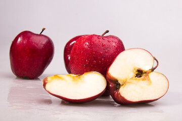 Fresh Red apple with cut in half and water droplets isolated on white background