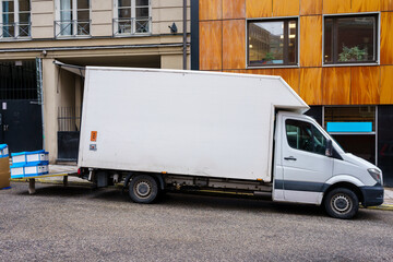 White delivery truck parked in front of building
