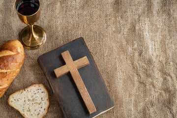 Cross, bible, wine and bread with copy space background. Maundy Thursday concept.