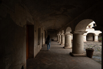 Woman walking inside a dark colonial building in Antigua Guatemala