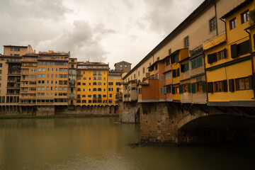 The Ponte Vecchio bridge in Florence, Italy, lined with colorful medieval buildings over the Arno River.