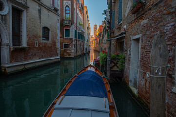 Gondola Navigating a Narrow Canal in Venice, Italy
