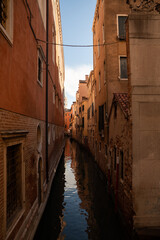 Sunlit Canal with Historic Buildings in Venice, Italy
