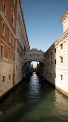 Sunlit Canal with Historic Buildings in Venice, Italy
