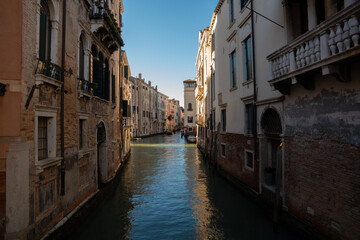 Sunlit Canal with Historic Buildings in Venice, Italy
