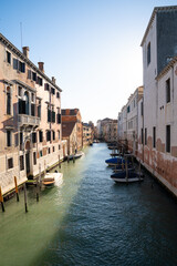 Sunlit Canal with Historic Buildings in Venice, Italy
