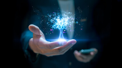 A businessman in a dark suit holds a glowing holographic tree made of digital data and network connections, symbolizing technology, innovation, and artificial intelligence. digital transformation.