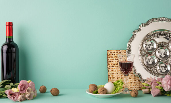 Passover side view items including a seder plate, matzot, and wine bottle arranged on green backdrop