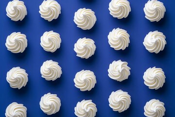 Whipped Cream Swirls Arranged on Blue Background in Symmetrical Pattern