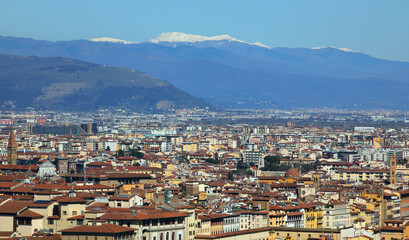 view of the many houses and buildings of a crowded city with mountains in the background