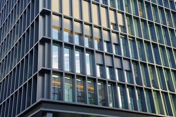 Modern office building with glass and metal facade. Corporate high rise building with geometric design and reflective windows. Contemporary architecture in urban business district