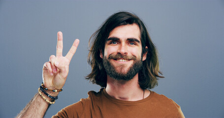 Man, peace sign and symbol in studio portrait, v icon and smile for victory by background. Model,...
