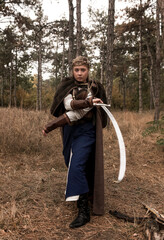 warrior girl with sword in hands in the forest