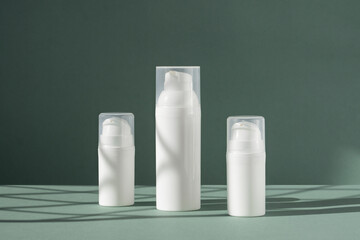 Cream tube, moisturizing foam and tonic water on shipping boxes on green background with Light on wall. White blank unbranded flacons with cosmetology products.